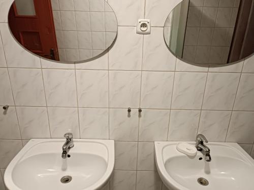 a bathroom with two sinks and a mirror at Hostel Sunrise Liwska in Warsaw