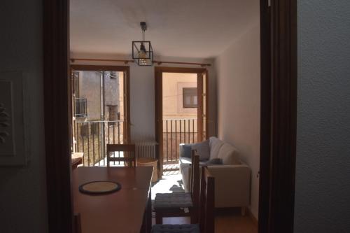 a living room with a table and a view of a balcony at Puerta del Hierro in Sigüenza
