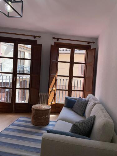 a living room with a couch and two windows at Puerta del Hierro in Sigüenza
