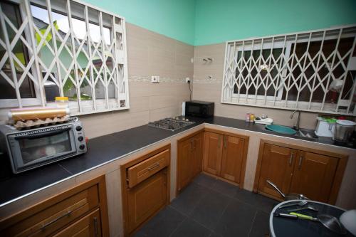 a kitchen with a stove and a microwave on a counter at Marysin Guest house in Accra