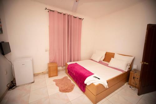 een slaapkamer met een bed met een rode deken bij Marysin Guest house in Accra