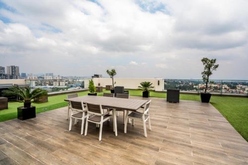 a patio with a table and chairs on a roof at Elite 47 Interlomas in Mexico City
