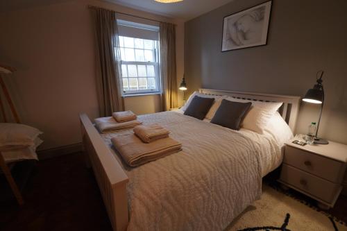 a bedroom with a white bed with towels on it at Walmer, Deal stunning coach house apartment in Walmer