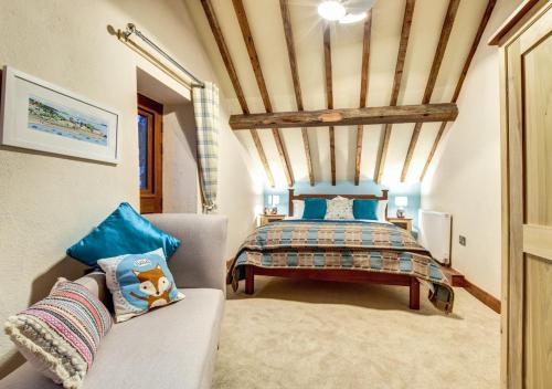 ein Schlafzimmer mit einem Bett und einem Sofa in einem Zimmer in der Unterkunft Trehafod in Menai Bridge