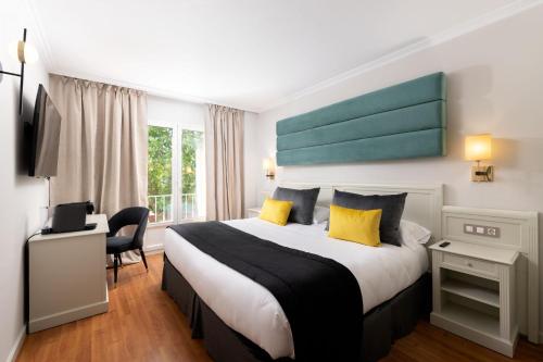 a hotel room with a large bed with yellow pillows at 1907 VILLA GIJON in Gijón