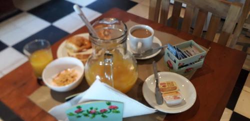 una mesa con un tarro de té y un plato de comida en Hotel Residencial Costanera, en Formosa