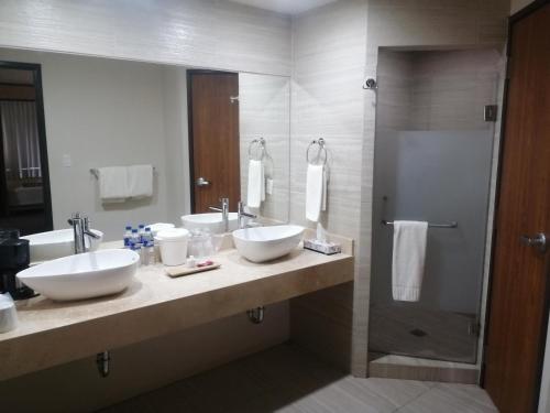 a bathroom with two sinks and a shower at Hotel La Mina Parral in Hidalgo del Parral