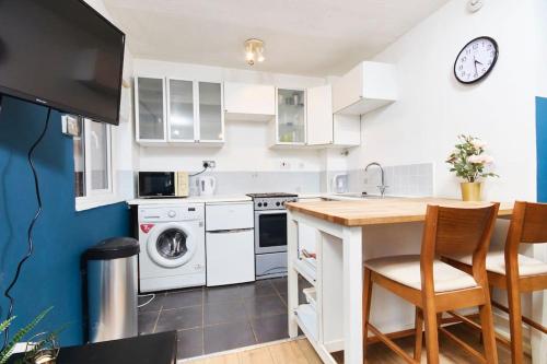 eine Küche mit weißen Geräten sowie einem Tisch und Stühlen in der Unterkunft Lovely Apt in City Centre Leeds in Leeds