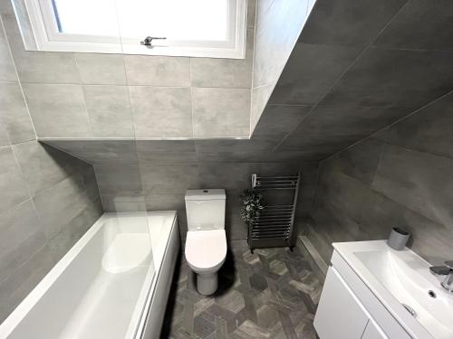 a bathroom with a toilet and a tub and a sink at Modern 2 Bedroom, 2 Bathroom Home with Parking in Stanley