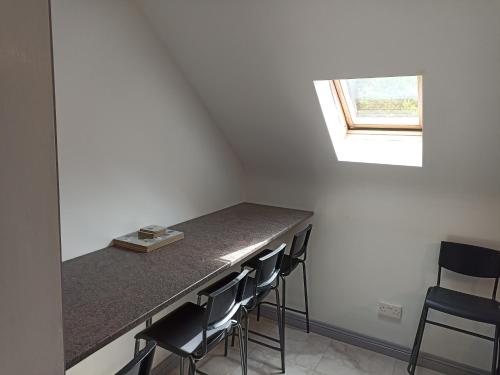 une cuisine avec un comptoir avec des chaises et une fenêtre dans l'établissement Foreen Lodge, Achill Island, à Achill