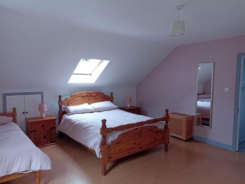 1 dormitorio con cama de madera y espejo en Foreen Lodge, Achill Island, en Achill