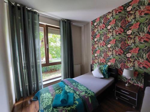 a bedroom with a bed and a large window at SAS Apartamenty Baron in Szczecin