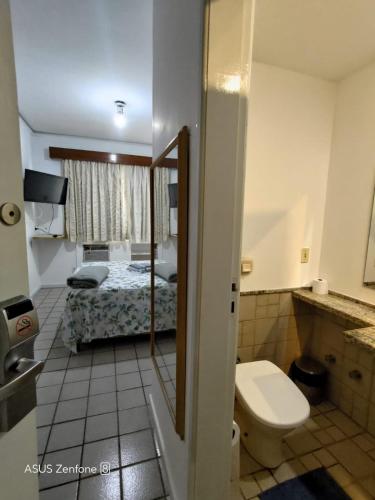 La salle de bains est pourvue de toilettes et d'un lit. dans l'établissement Flat Aconchegante na Orla de Camburi, à Vitória