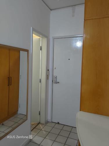 La salle de bains est pourvue de toilettes, d'un miroir et d'une porte. dans l'établissement Flat Aconchegante na Orla de Camburi, à Vitória