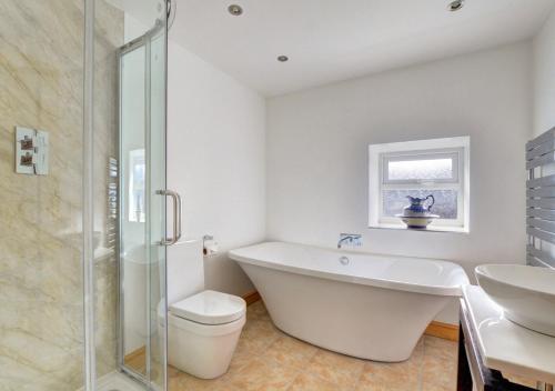 a bathroom with a tub and a toilet and a sink at Rhiwlas in Pennal