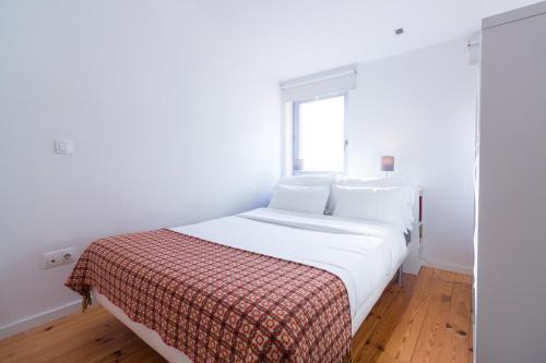 uma cama branca num quarto com uma janela em Oporto Near Violin no Porto