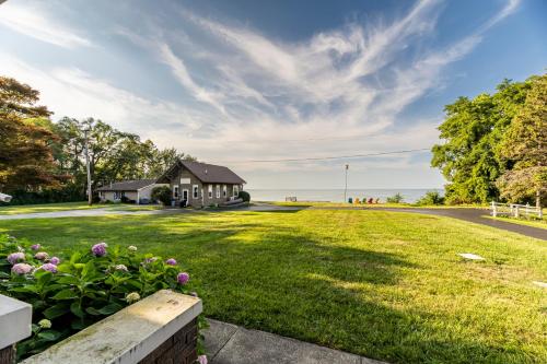 una casa en un campo de hierba con un edificio en Cozy Lakefront Cottage, en Huron