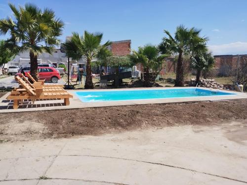 una piscina con tumbonas y palmeras en La Gracia en Salta