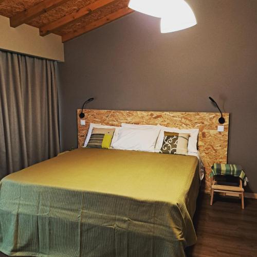 a bedroom with a large bed with a brick wall at Poço e Meio - Padel & Pool in Santiago da Guarda