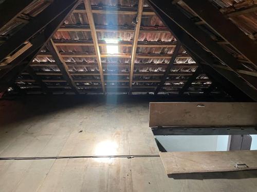 a attic with a wooden floor and a wooden table at Deesha Homes in Wayanad