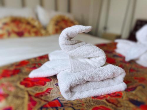 una pila de toallas blancas sentadas en una cama en Bristol City Stays - Cabot Circus, en Bristol