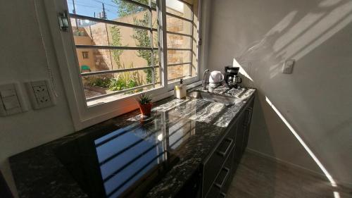 a kitchen with a sink and a window at Adrogue Apart Airport Shuttle 24hs in Burzaco
