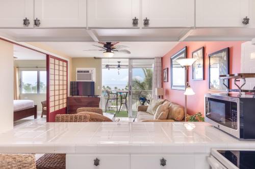 a kitchen and living room with a couch and a tv at Kailua Village Resort 605 in Kailua-Kona