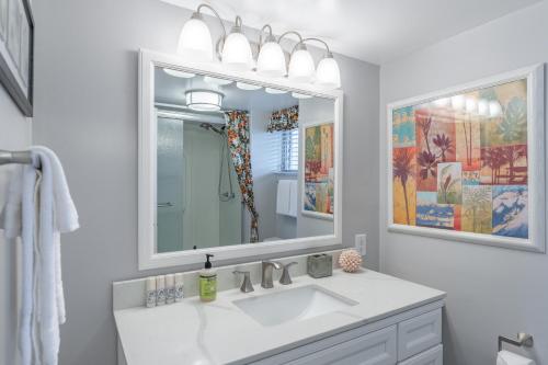 a white bathroom with a sink and a mirror at Kailua Village Resort 605 in Kailua-Kona