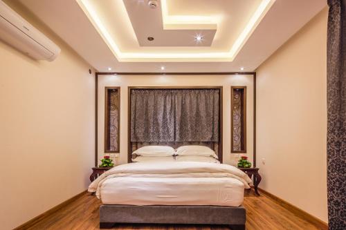 利雅德的住宿－瑞文宮殿酒店，一间卧室设有一张带格子天花板的床。
