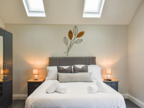 a bedroom with a large white bed with two lamps at The Old Fox Lodge in Ruabon