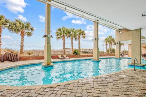 a swimming pool with palm trees in the background at Bahama Sands Condos in Myrtle Beach