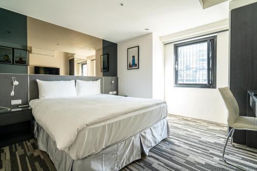 a hotel room with a large bed and a desk at Hotels Here - Taipei in Taipei