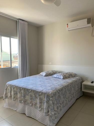 a bedroom with a large bed with a window at Bouganville Guest House BC in Balneário Camboriú
