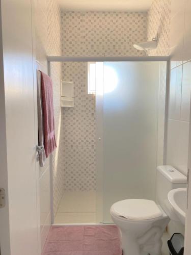 uma casa de banho branca com um WC e um chuveiro em Bouganville Guest House BC em Balneário Camboriú