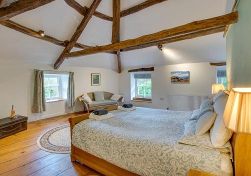 a bedroom with a large bed and a chair at Gellilwyd Fach in Dolgellau