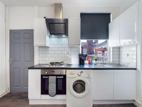 a kitchen with a washing machine and a sink at Whitmore House By RMR Accommodations - Newly Refurbed - Modern - Parking - Central in Etruria