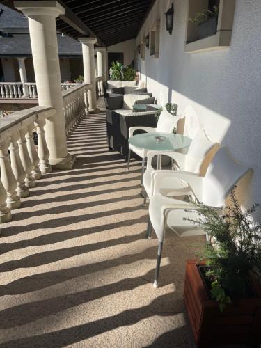 uma fila de cadeiras e mesas brancas num pátio em Hotel L'Empire em Olm