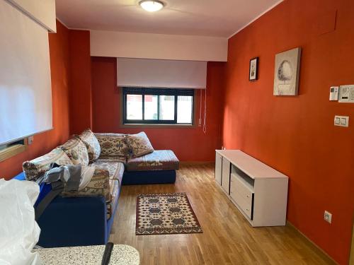a living room with orange walls and a couch at Casa Amelia in Mondariz-Balneario