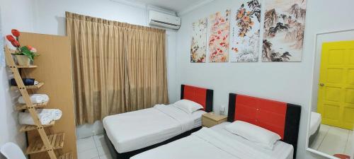 a small room with two beds and a window at Kota Kinabalu Sabah City Homestay in Kota Kinabalu