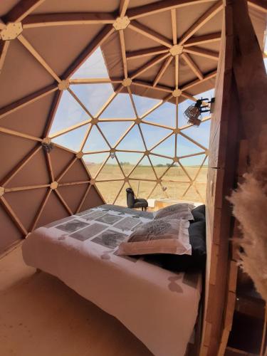 un lit dans une chambre avec une grande fenêtre dans l'établissement A l'aube des sens, à Bailly-le-Franc