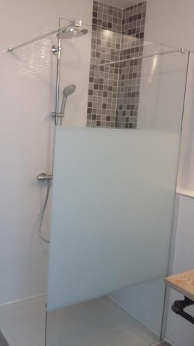 une douche avec une porte vitrée dans une salle de bain dans l'établissement Maison indépendante proche RN4, à Aulnois-en-Perthois