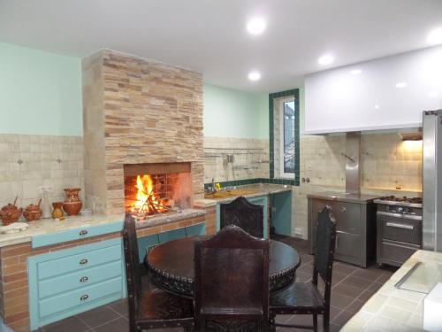 a kitchen with a fireplace and a table and chairs at Casal de S.Romão do Meio in Guimarães