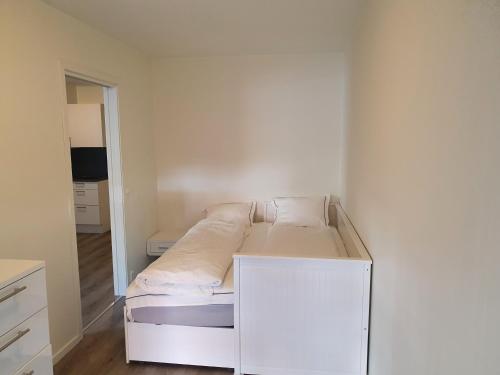1 cama blanca pequeña en una habitación pequeña en Apartment in Frogner Lillestrøm - Modern and Central, en Lillestrøm