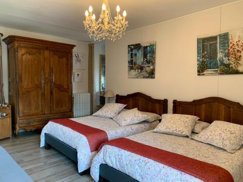 1 dormitorio con 2 camas y lámpara de araña en Logis de La Roche - Niort - Chauray, en Chauray