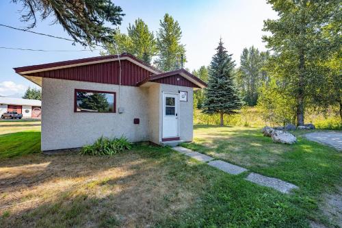 a small house with a white door in a yard at Downie Cottage by Revelstoke Vacations in Revelstoke