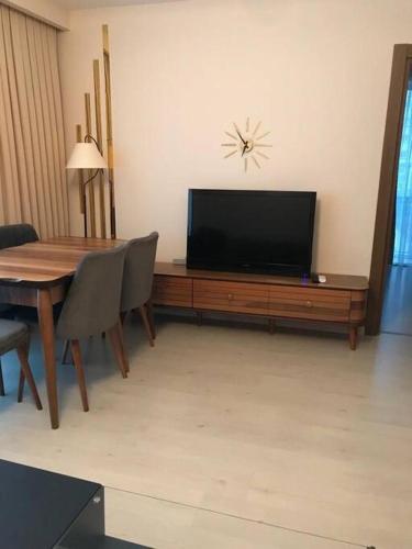 uma sala de estar com uma mesa e uma televisão de ecrã plano em الراحه والاستجمام من ارقى المجمعات بتركيا(1+1) 33 em Basaksehir