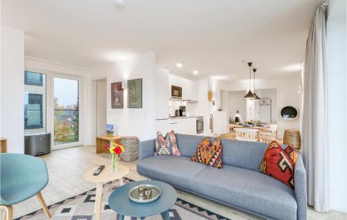 Una sala de estar con un sofá azul y una cocina. en Beach Front Apartment, en Lembruch