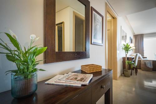 Una sala de estar con una mesa con una planta encima. en Sotogrande - Ribera del Marlín, en Sotogrande