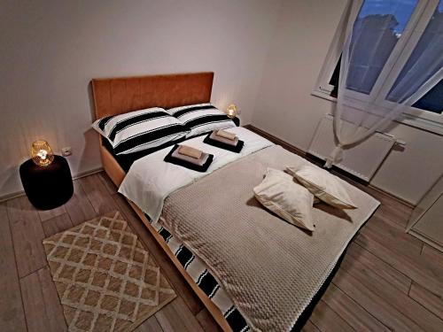 a bedroom with a bed with two pillows and a window at GOLDEN - self CHECK IN in Osijek