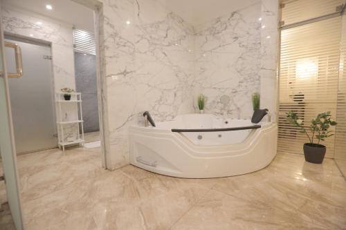 a white bathroom with a tub and a sink at برود in Taif